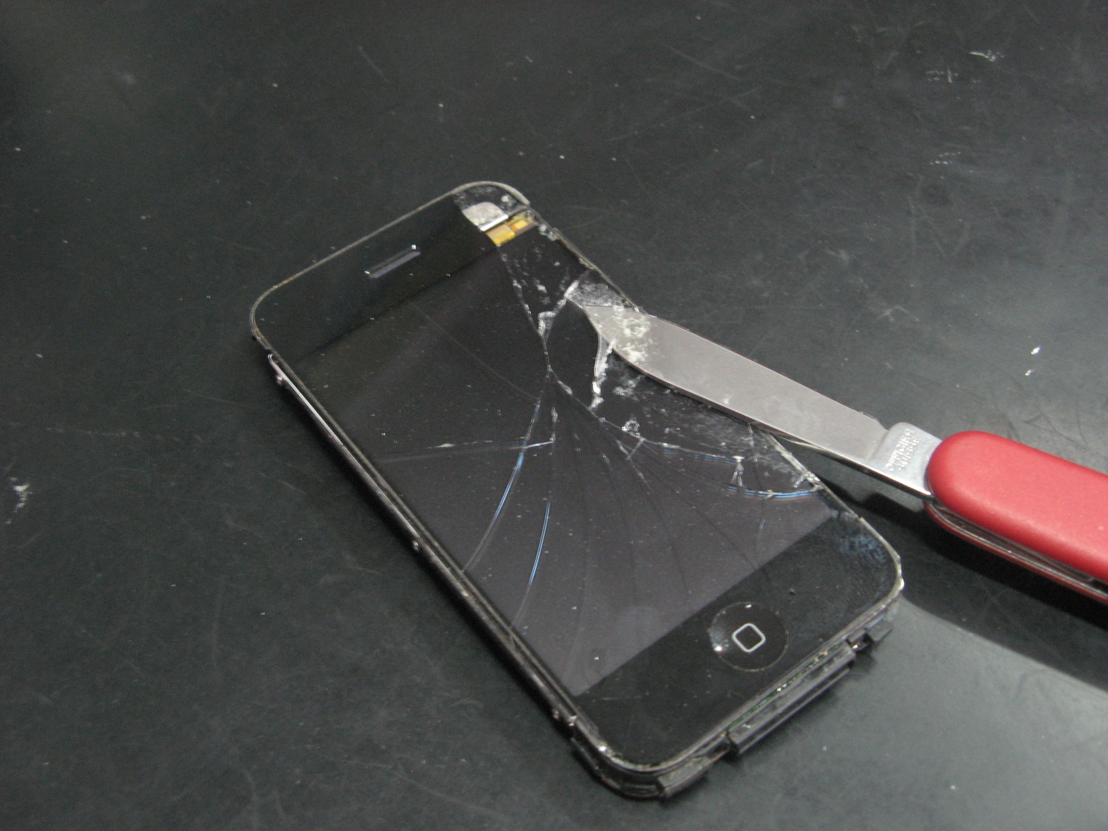 Аккуратно подсовываем ножик под стекло iPhone 2G